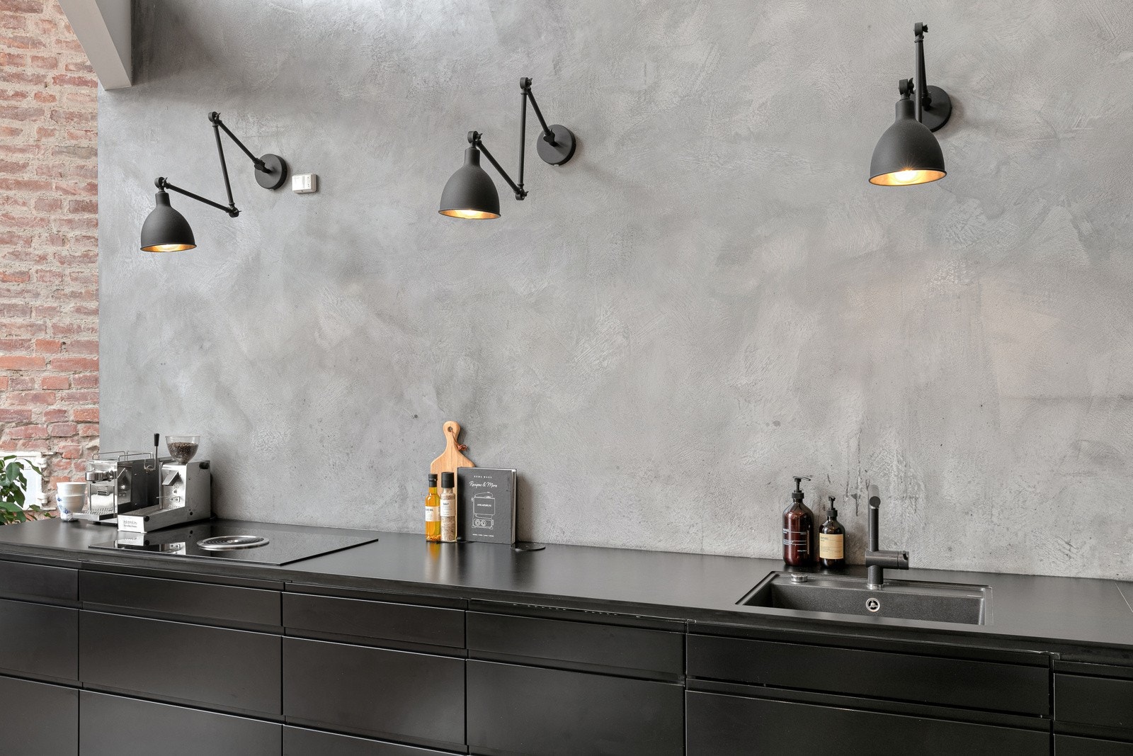 Innredningen har slette sorte fronter og komprimert-laminat benkeplate med platelimt oppvaskkum. Galleribilde