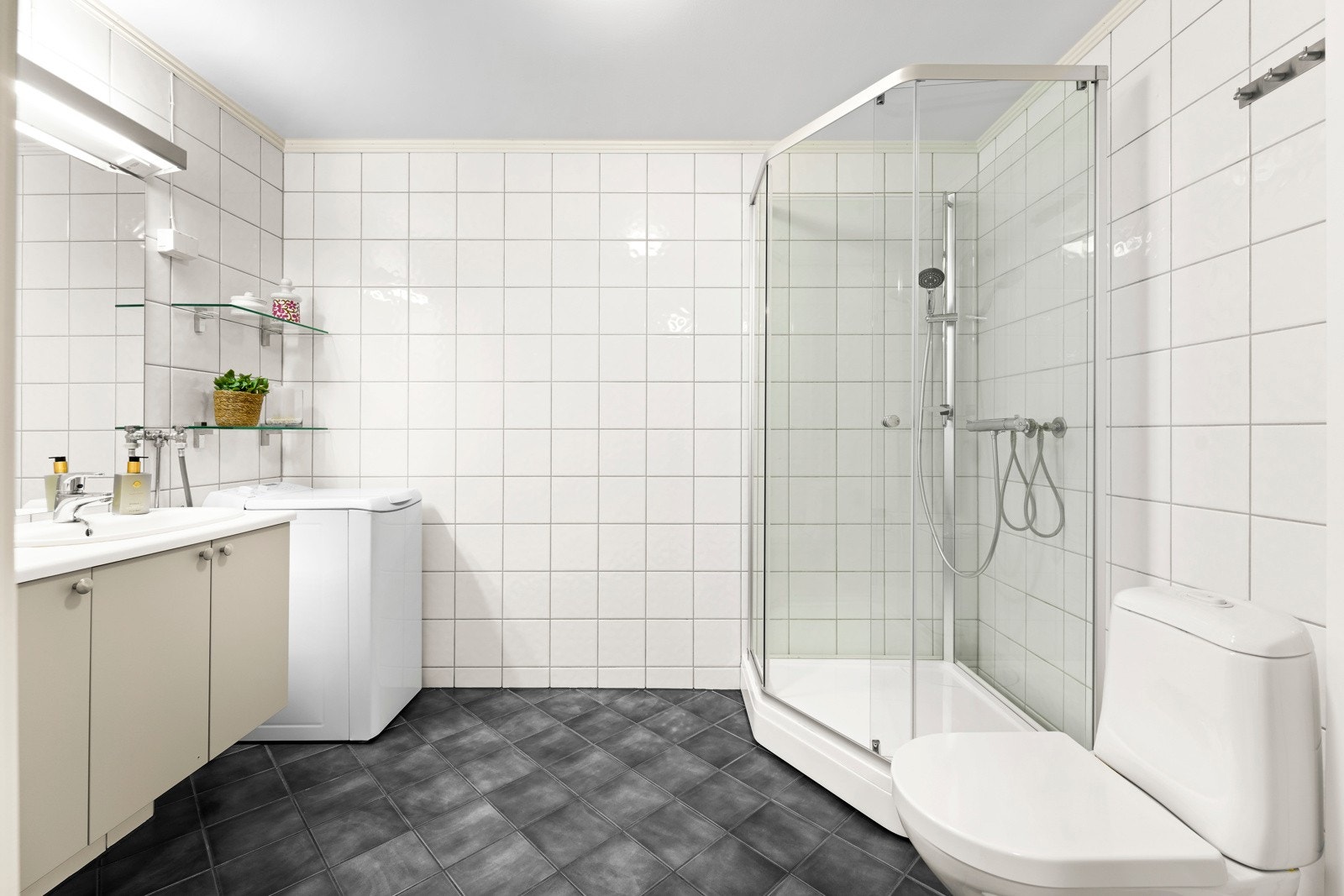 Badet oppleves som praktisk med flislagte overflater, gulvvarme og mekanisk avtrekk. Galleribilde