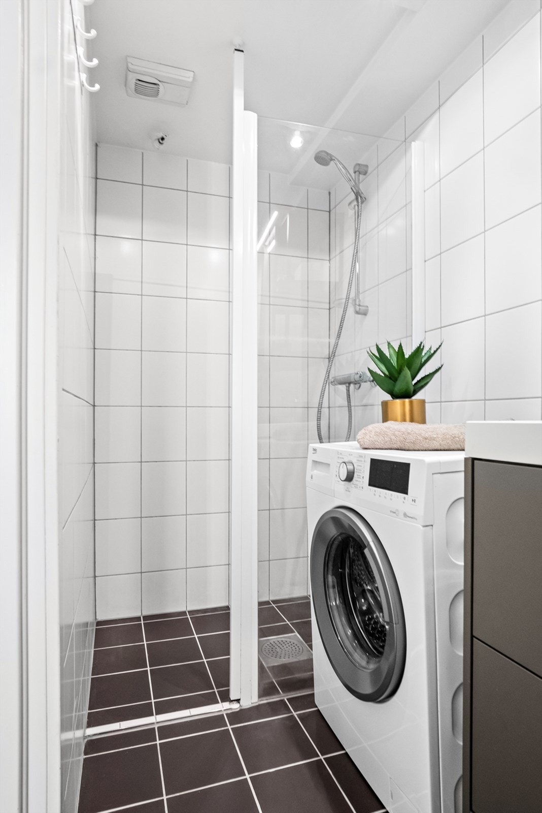 Pent flislagt bad fra 2006 med dusjnisje med glassvegg, avtrekksvifte og opplegg for vaskemaskin. Galleribilde