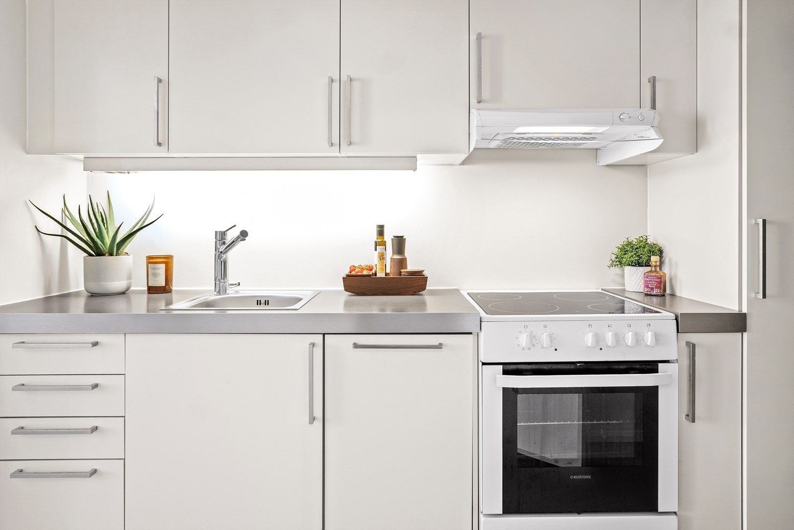 Kjøkkenet har laminat benkeplate, oppvaskkum, oppvaskmaskin, komfyr og ventilator. Galleribilde