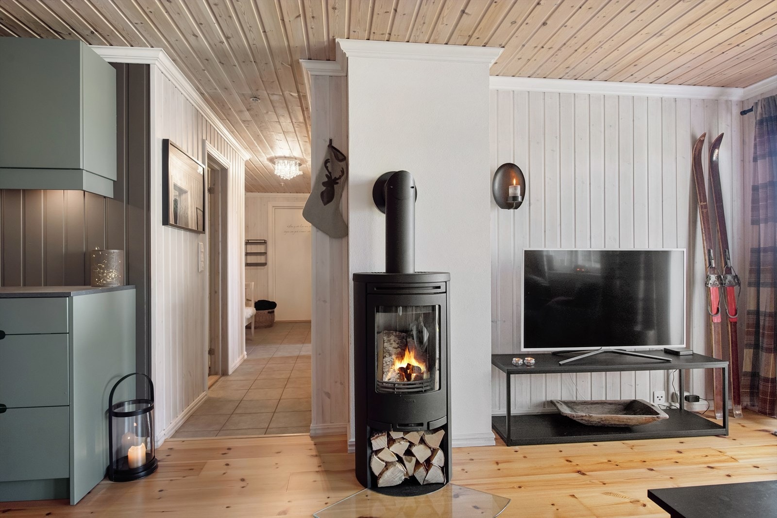 Plassert sentralt i rommet, fungerer peisovnen både som en varmekilde og et estetisk blikkfang, og bidrar til å gjøre stuen til et innbydende sted for avslapning og hygge. Galleribilde