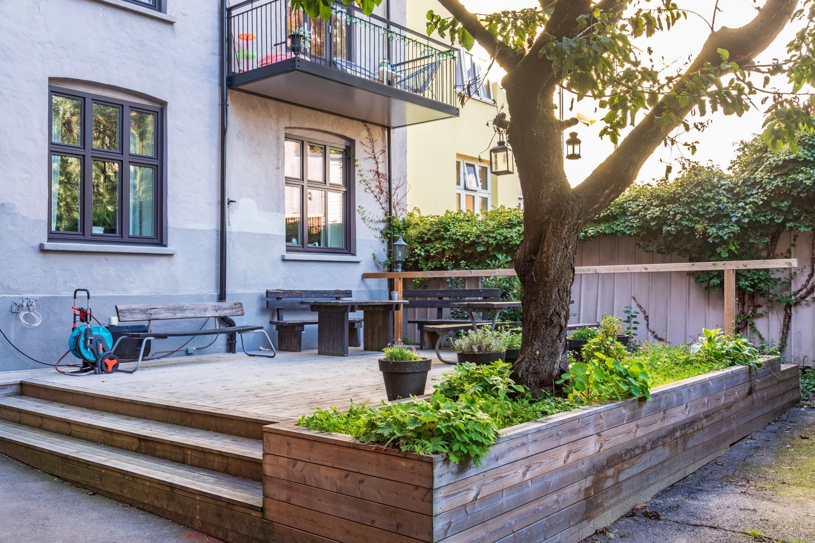 Opparbeidet og skjermet gårdsrom med terrasseplatting, sykkelstativ, benker og beplantning. Galleribilde