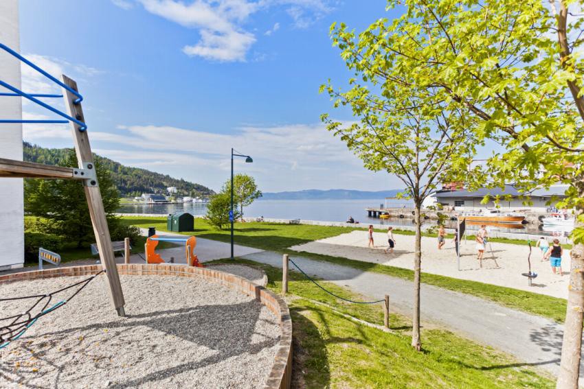 Nede ved sjøen, ca. 100 m fra boligen, er det opparbeidet promenade med utstrakt plenareal, volleyballbane, leke- og badeplasser. Galleribilde