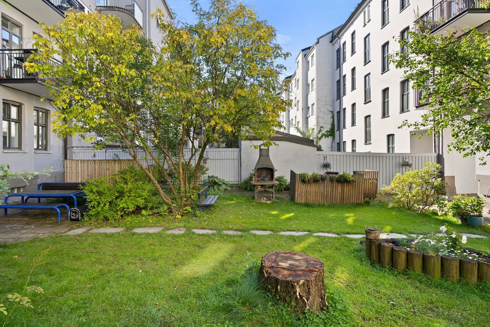 Pent opparbeidet fellesareal i bakgården med sittegrupper og beplantning. Galleribilde