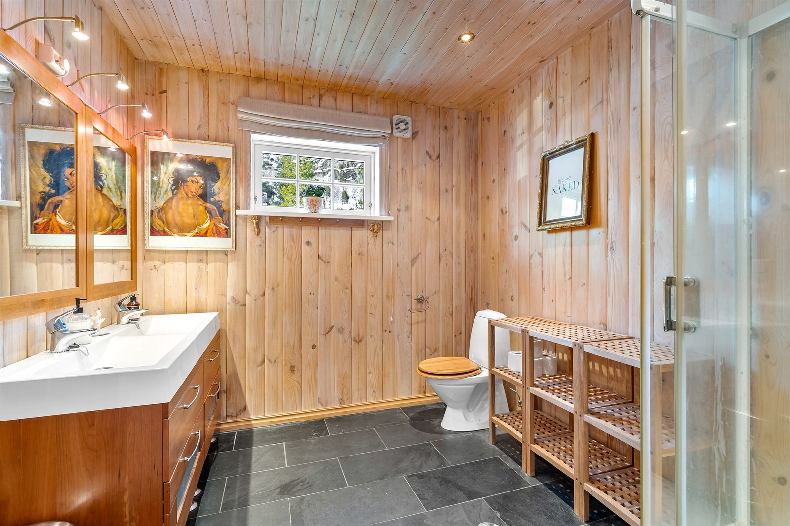 Bad av god størrelse med toalett, servant og dusjkabinett Galleribilde