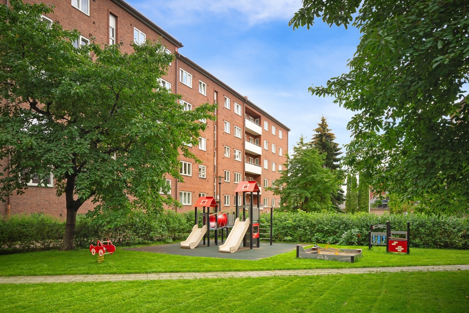 Borettslagets store og hyggelige bakgård - en grønn oase med gressplen, trær, stauder, rosebed og et vell av prydbusker. Gangarealene er steinsatte, det er anlagt lekeplass og satt ut benker og bord til felles glede. Galleribilde