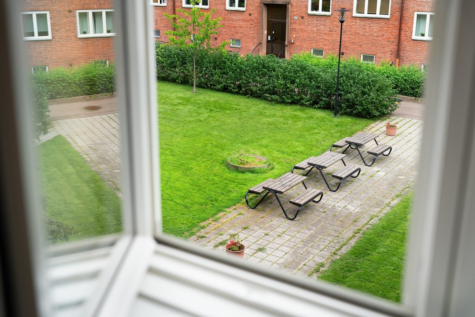 Vindu mot idyllisk bakgård. Galleribilde