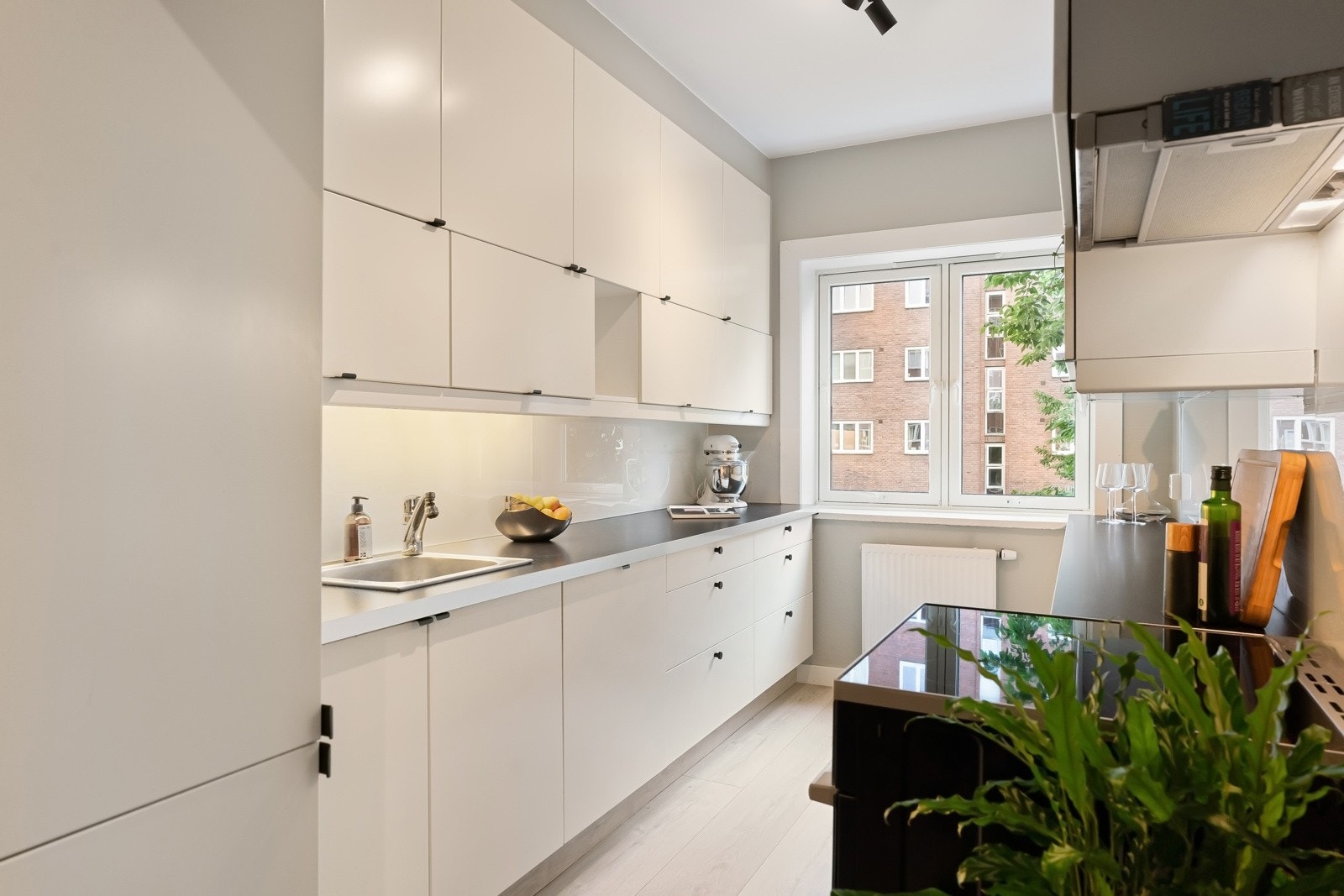 Kjøkkenet ligger i eget rom med østvendt vindu mot idyllisk bakgård. Rommet har enstavs laminatgulv fra 2019, lysmalte veggflater, listefri himling og ekstra takhøyde. Galleribilde