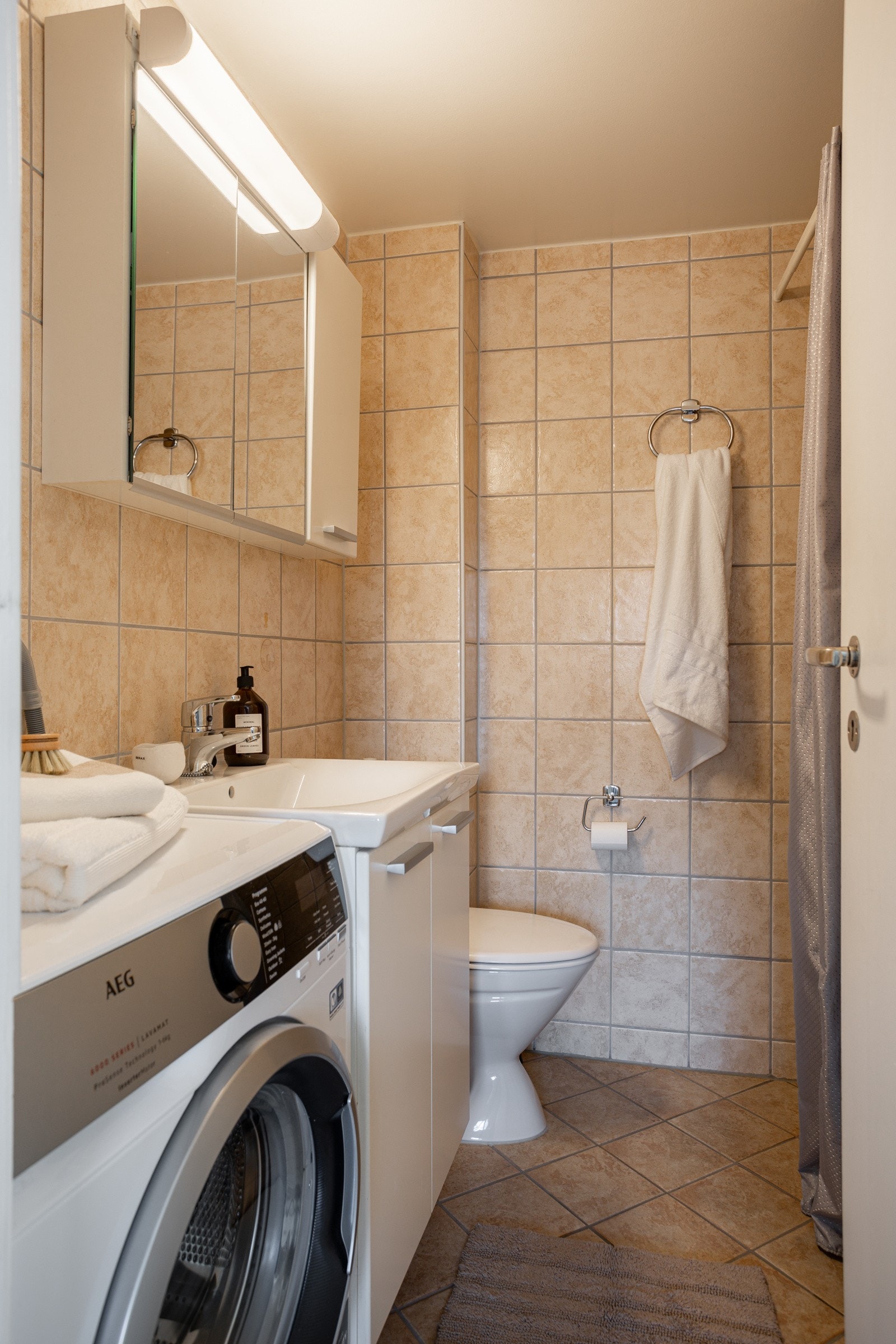 Badet har opplegg for vaskemaskin og varmekabler på gulvet. Galleribilde