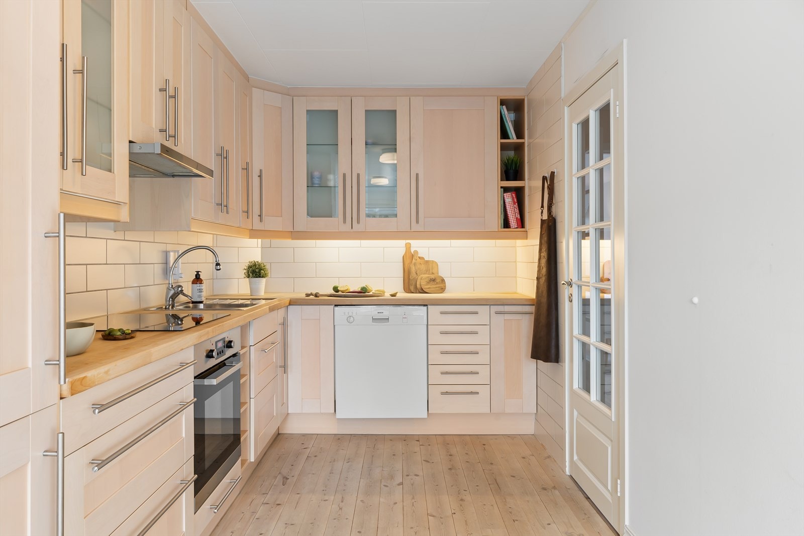 Kjøkkenet har lyse fronter og flott tregulv Galleribilde