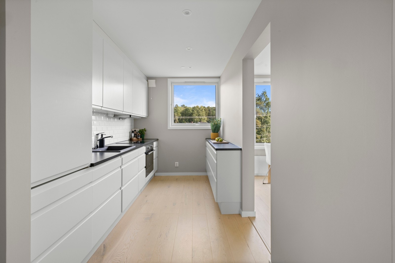 Lekkert åpent kjøkken med integrerte hvitevarer Galleribilde