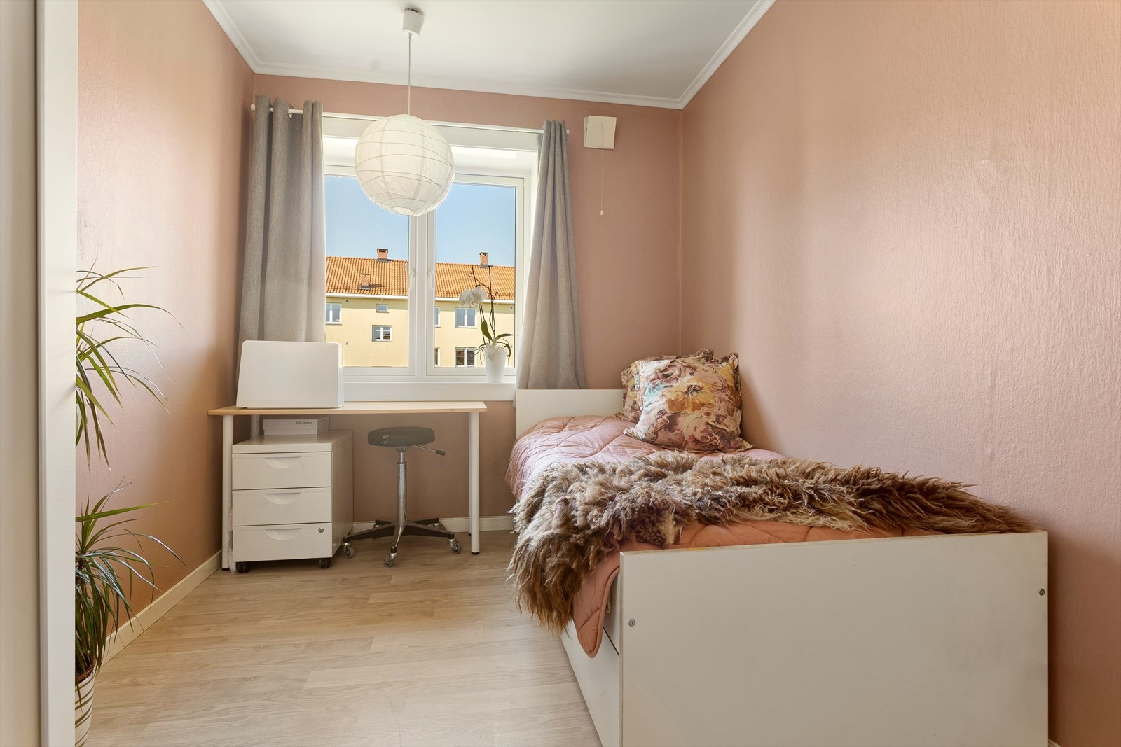 Dette rommet er malt i en lyserosa farge og har også et stort vindu. Galleribilde