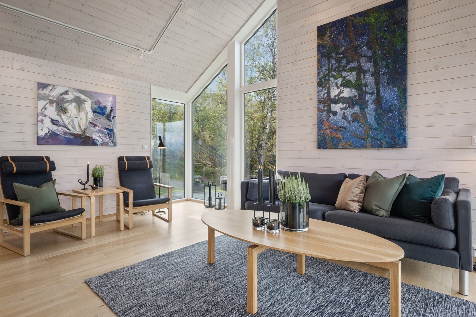 Hytta har store vindusflater og listefrie overganger mellom vegg og tak. Galleribilde