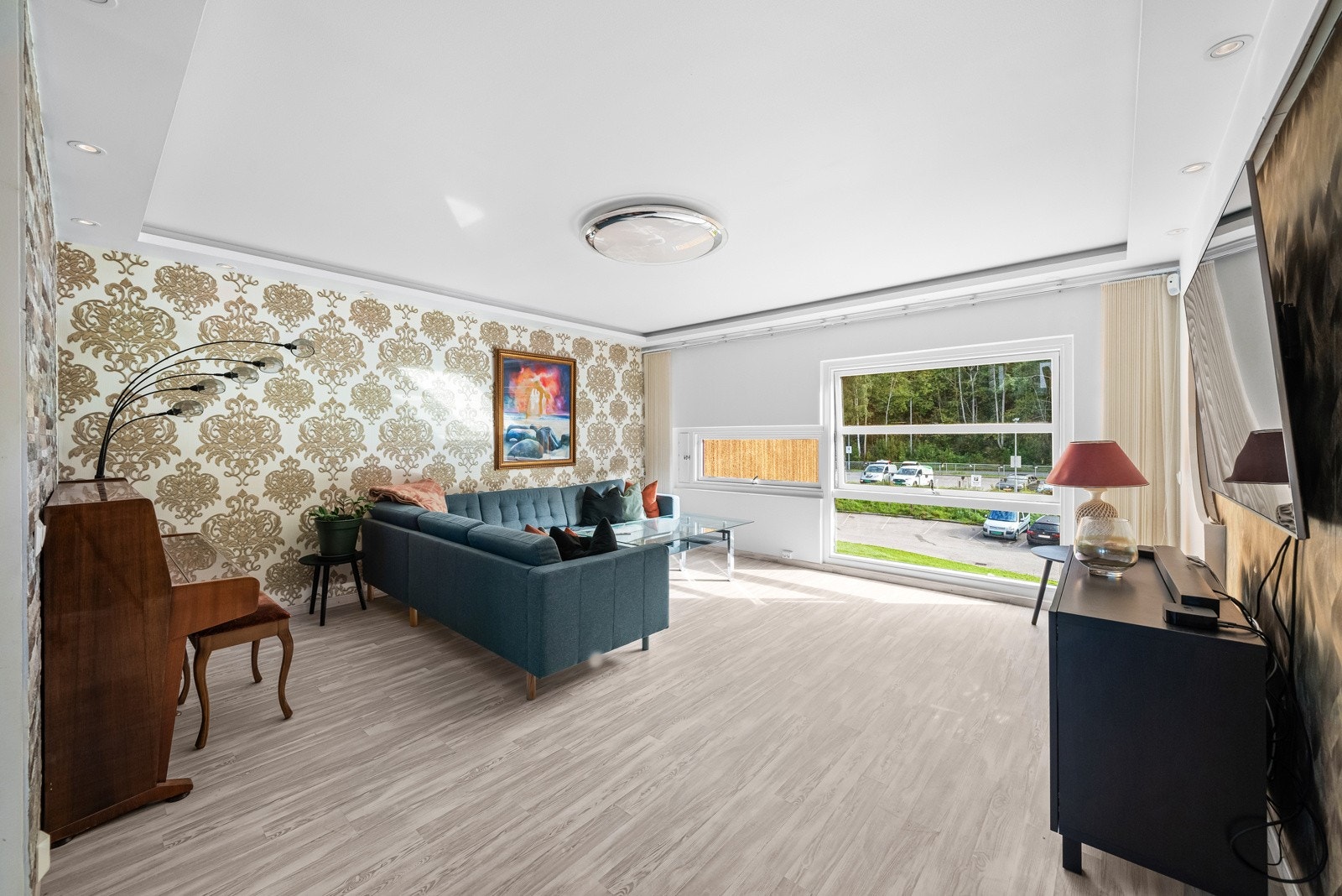 Stuen byr på en behagelig atmosfære hvor det store vinduet slipper inn rikelig med naturlig lys, som gir rommet en åpen og luftig følelse. Galleribilde