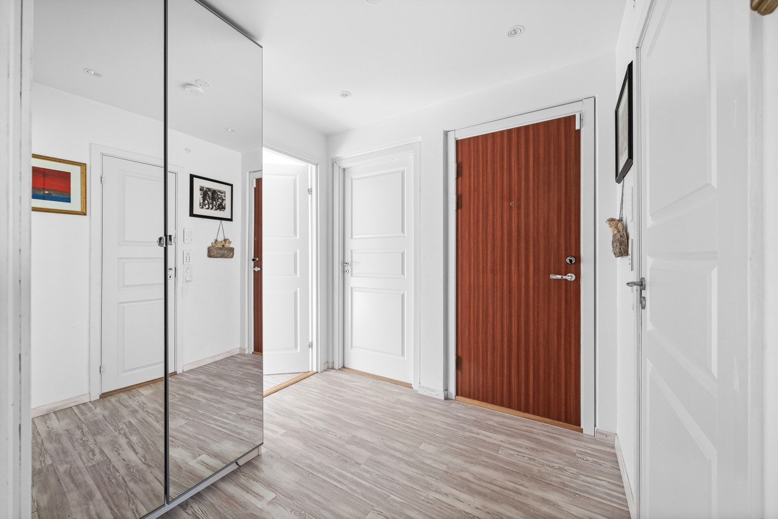 Boligen ønsker deg velkommen inn med en lys og innbydende entre. Her er det laminat på gulv, garderobeskap med speil og spotter i taket som gir et moderne preg. Galleribilde