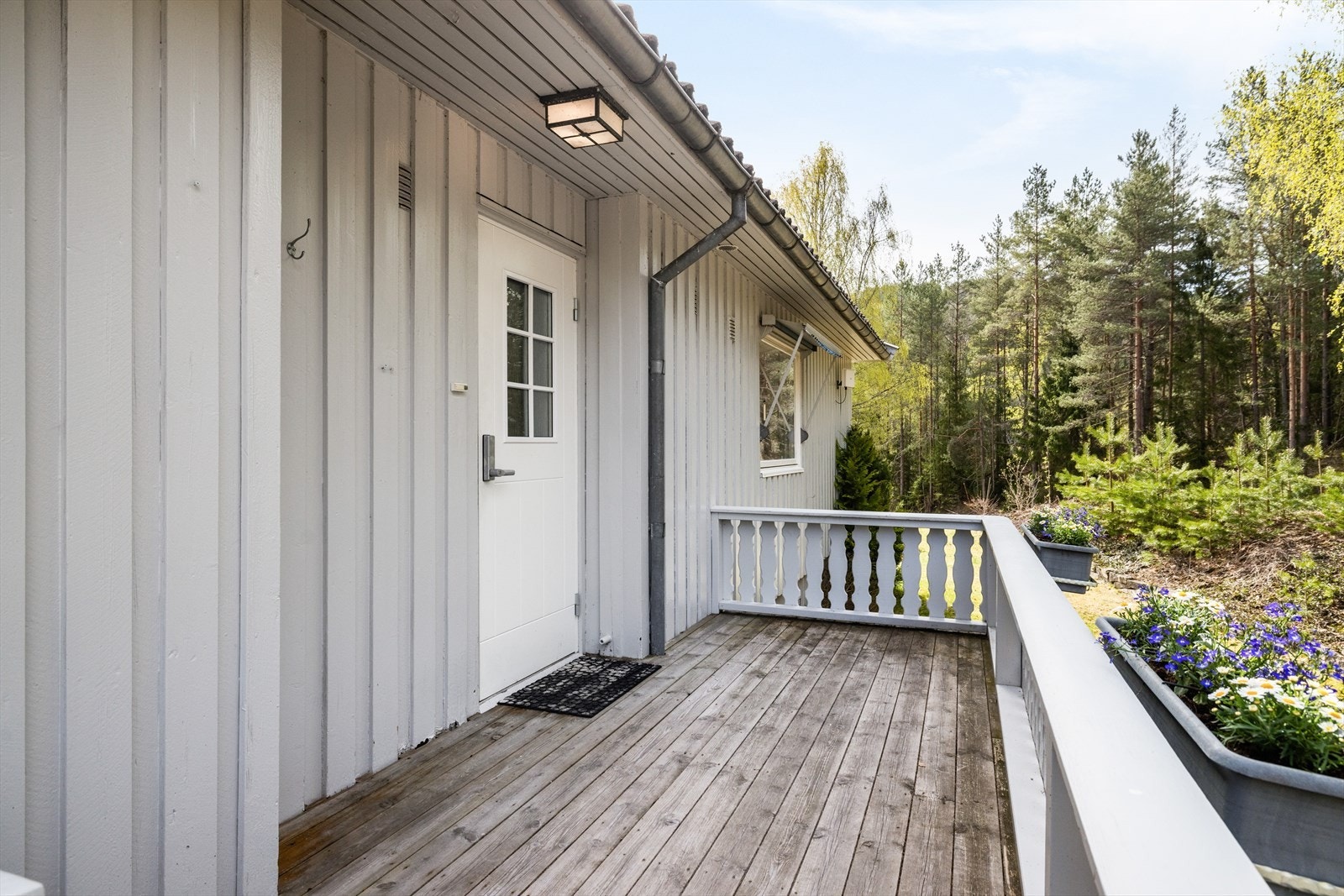 Boligen har et pent inngangsparti med plass til en liten sittegruppe eller blomsterpotter. Galleribilde
