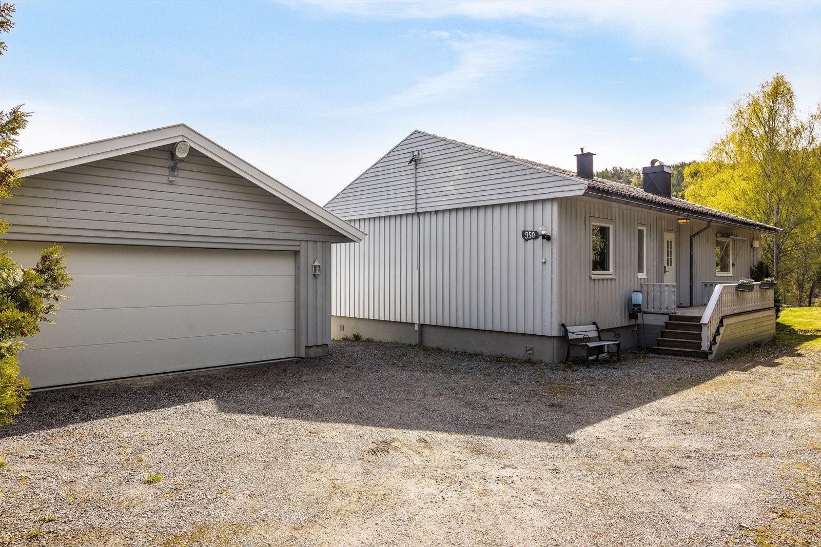 Det er gruslagt gårdsplass med parkering i garasje. Galleribilde