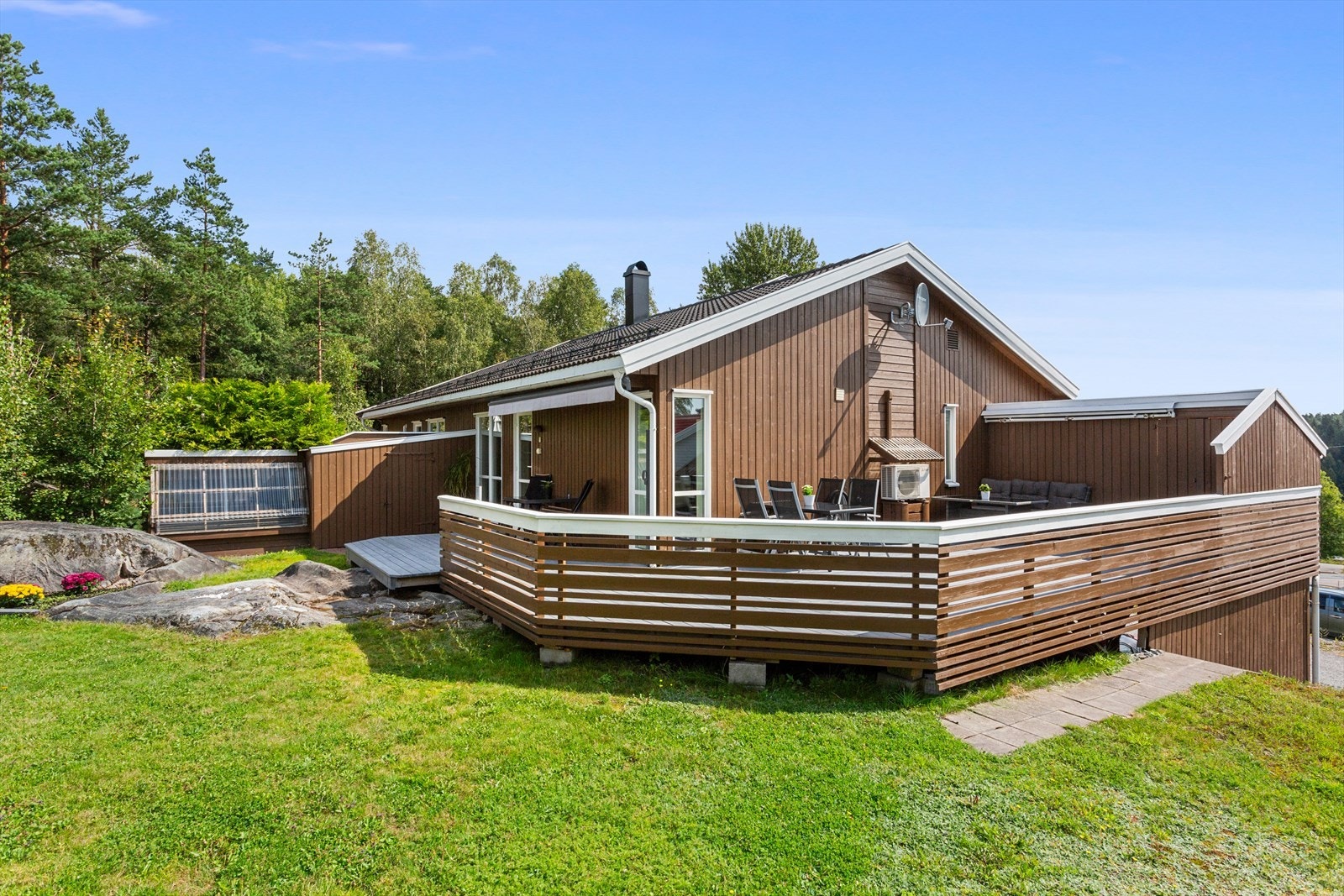Tomten er opparbeidet med gressplen og blomsterbed. Galleribilde