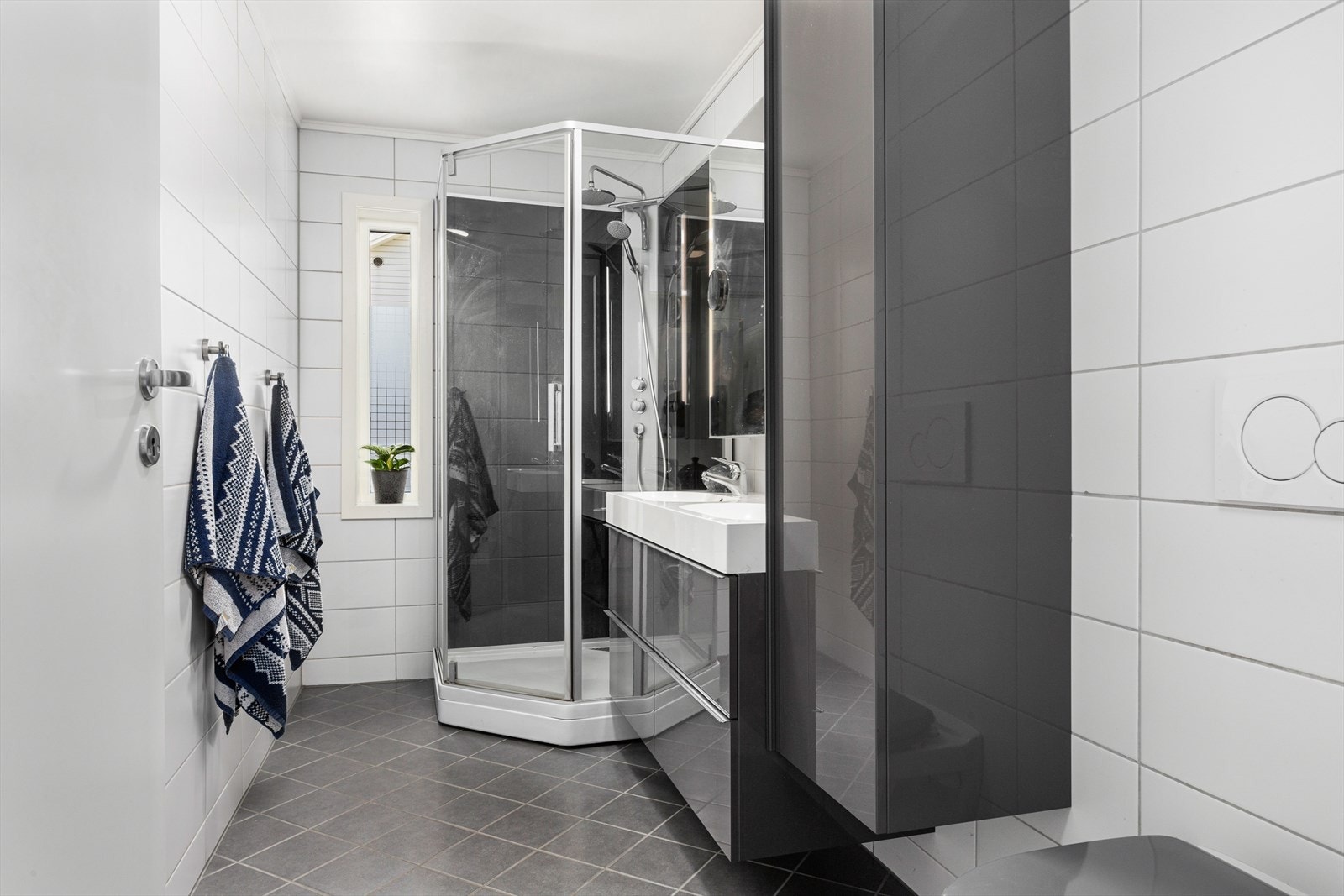 Badet består av servant med innredning, dusjkabinett og vegghengt klosett. Galleribilde