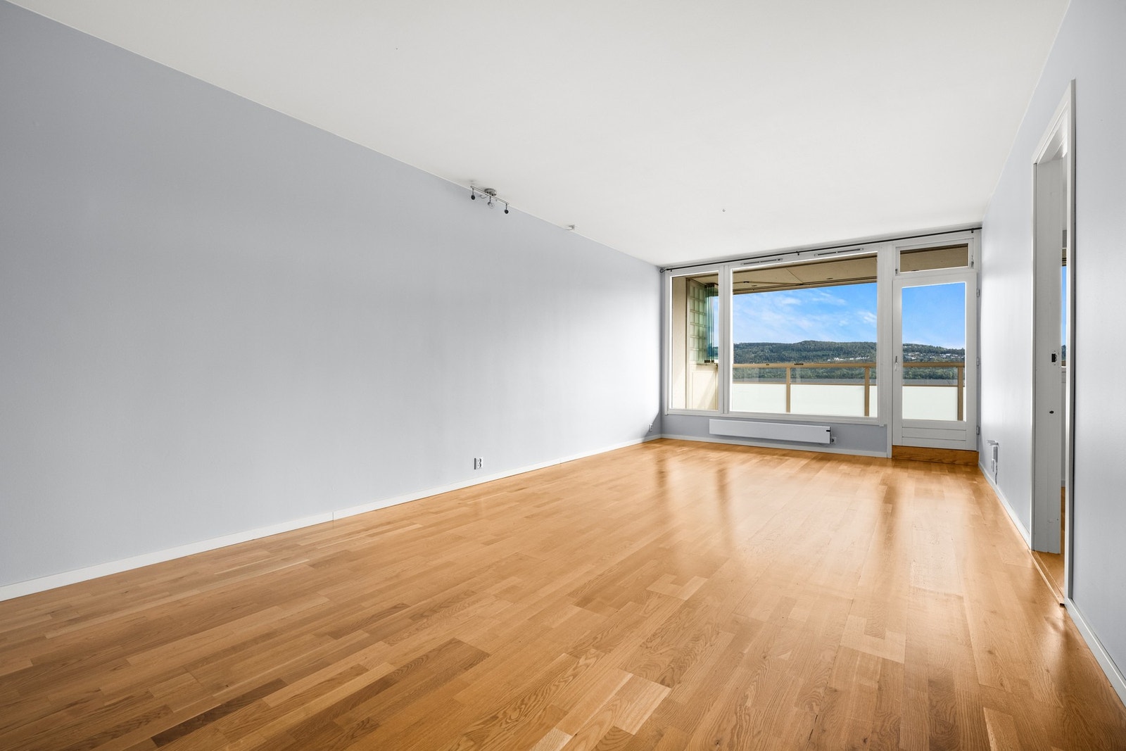 En romslig stue med utgang til innglasset balkong Galleribilde