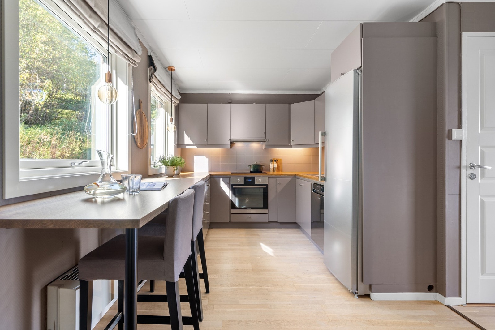 Kjøkken med mye skap- og benkeplass og flis over benk. Kjøleskapet (Gram, fra 2020) kan kjøpes. Galleribilde