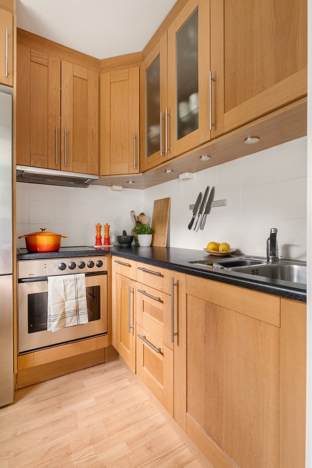 Kjøkkeninnredning med glatte fronter. Laminat benkeplate med nedfelt vask- og skyllekum. Galleribilde