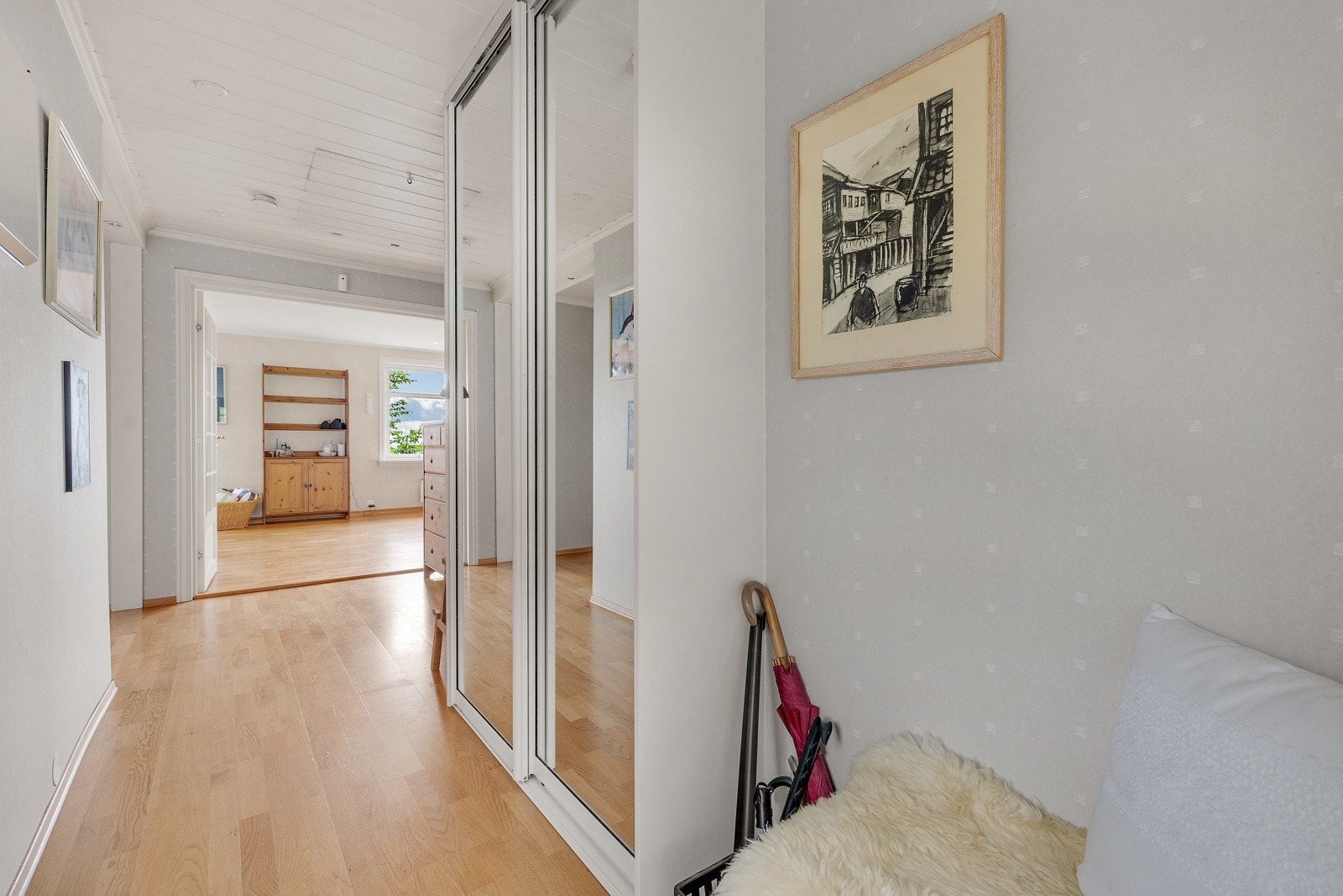 Videre er det ankomst til en hall med parkettgulv og en stor skyvedørsgarderobe. Galleribilde