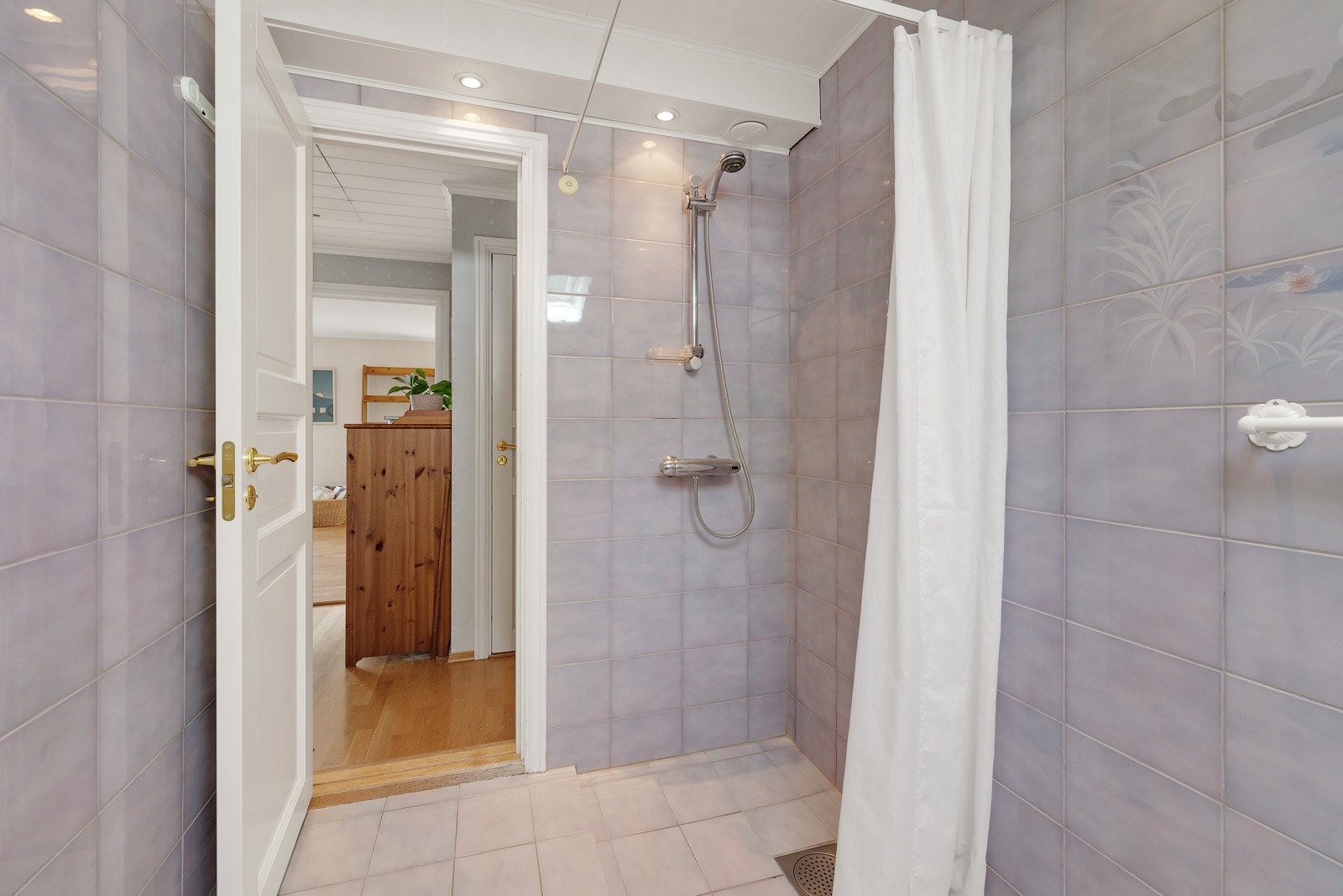 badet har et dusjhjørne med forheng og vegghengt dusjarmatur (hånddusj). Galleribilde
