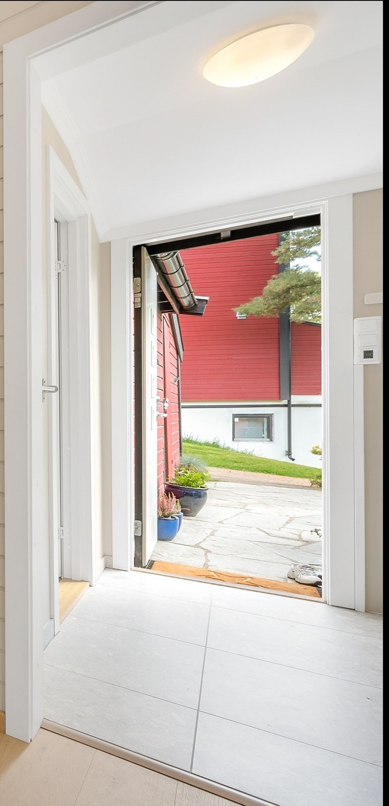Enkelt og pent inngangsparti med plass til å sette fra seg sko og knagger til å henge fra seg jakker. Galleribilde