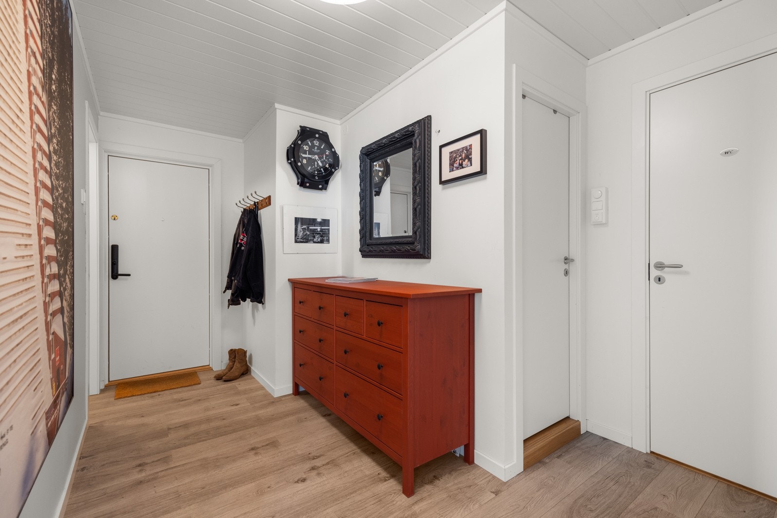 Vel inne blir vi ønsket velkommen i en lys og pen entré med hvite og laminat på gulvet Galleribilde