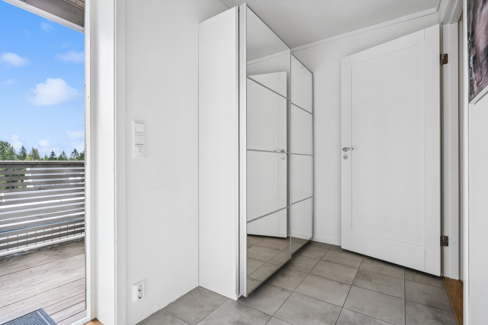 Leilighetens entré er lys og romslig. Her har du plass til garderobe der du kan heng fra deg yttertøy og sette fra deg sko. Galleribilde