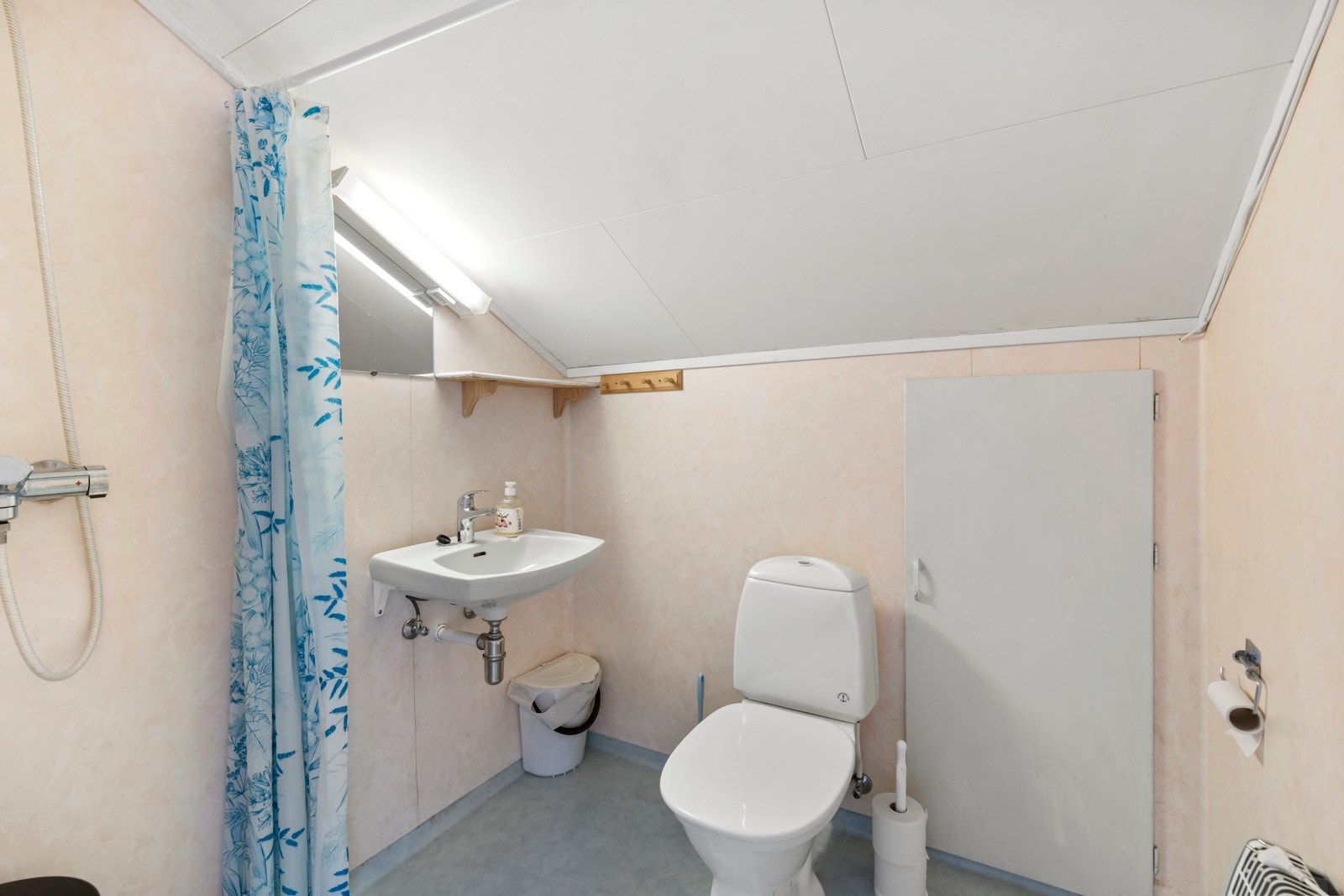 Badet i loftsetasjen er utstyrt med dusj på vegg, servant og toalett Galleribilde