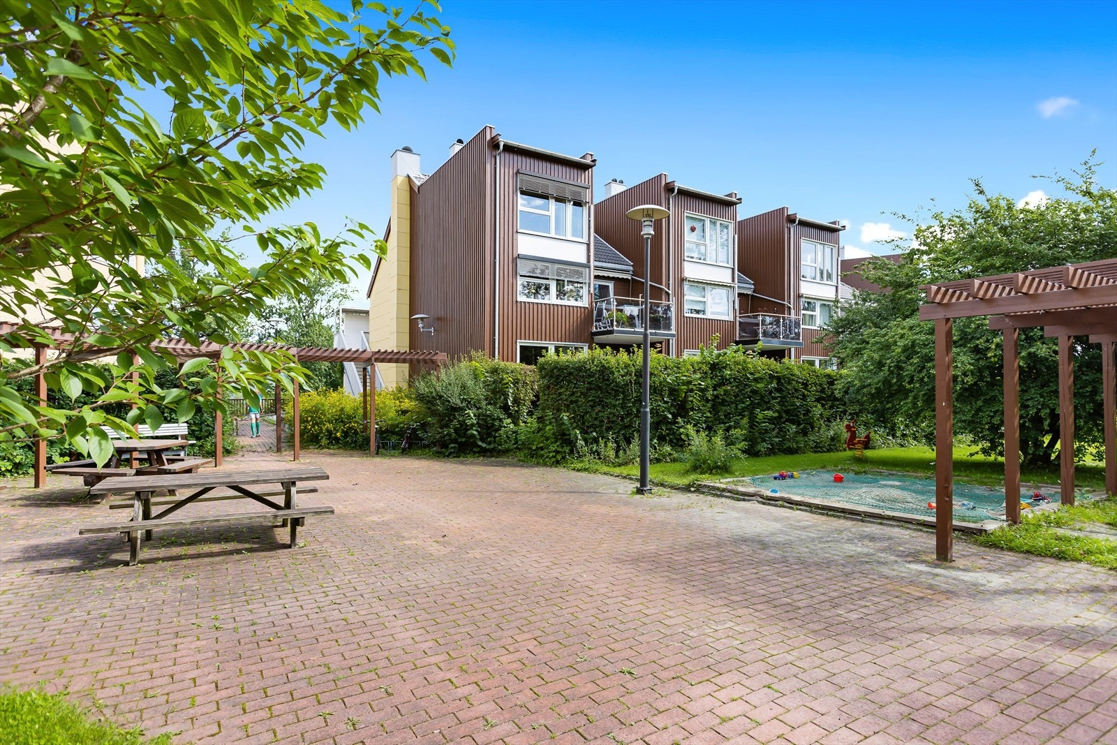 Felles uteområde med sitteplasser og lekeplass. Galleribilde