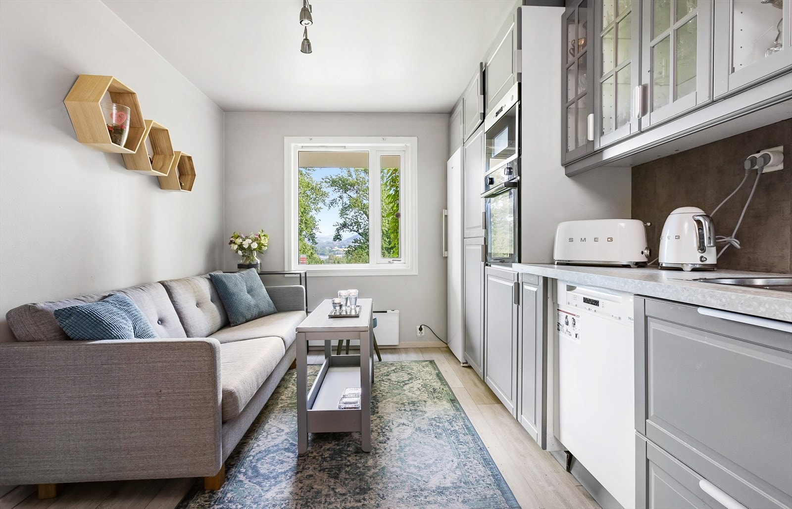 Leiligheten er gjennomgående, noe som gir rikelig med naturlig lys. Kjøkkeninnredning med profilerte folierte fronter. Enkelte glassfronter i overskap. Belysning under overskap. Fliser på vegg over benkeskap. Galleribilde