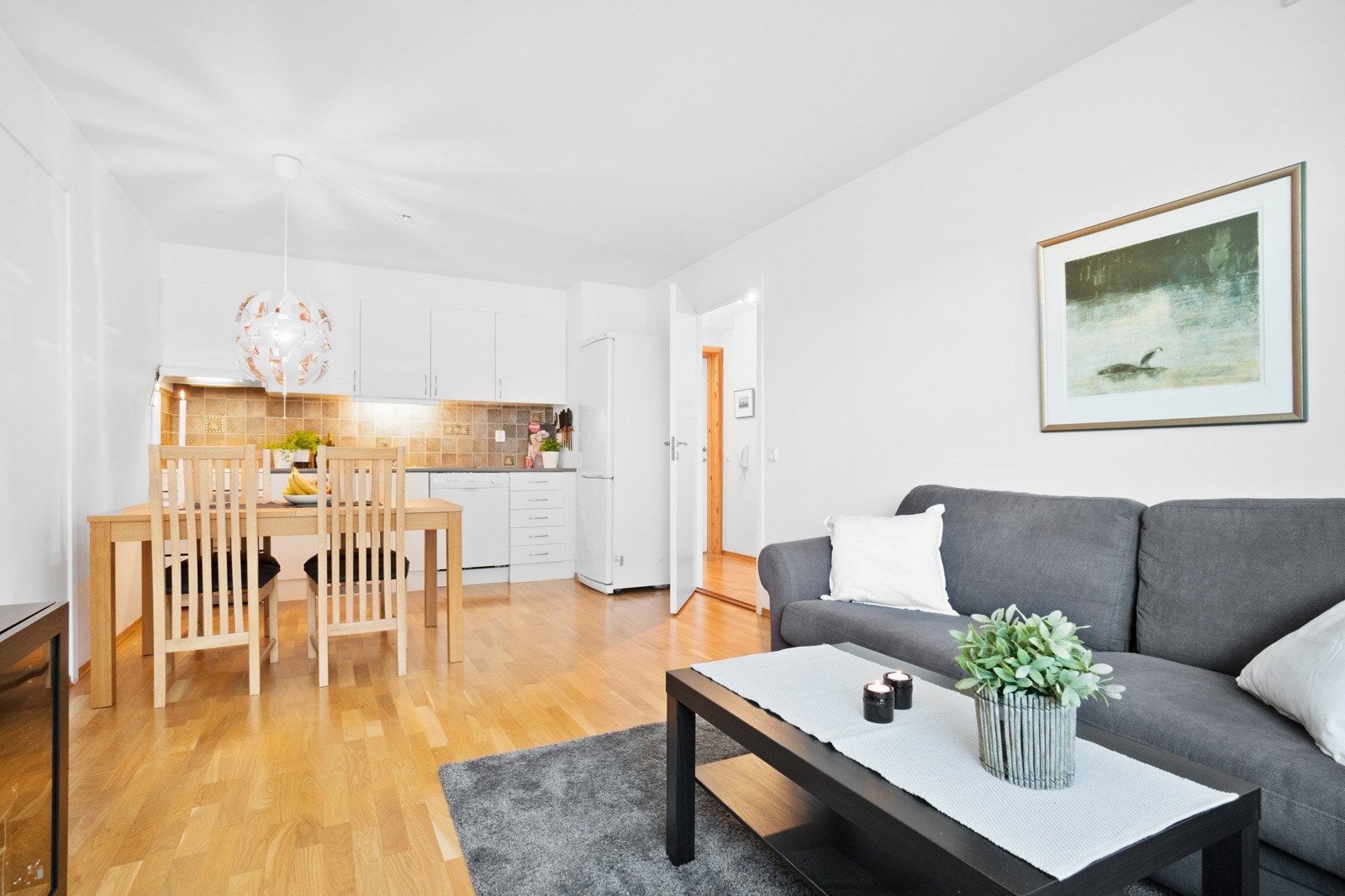 Åpen løsning mellom stue og kjøkken gir maksimal utnytelse av arealet. Her er det plass til sofa- og spisebordløsninger. Galleribilde