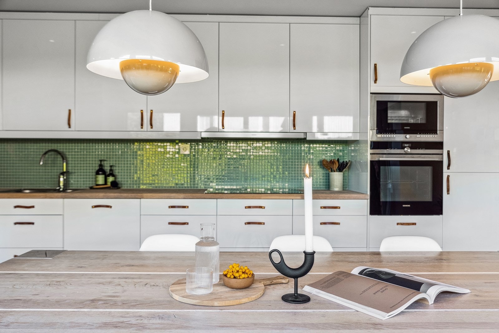 Innredningen er med lyse slette fronter og heltre benkeplate med nedfelt oppvaskkum i rustfritt stål. Galleribilde