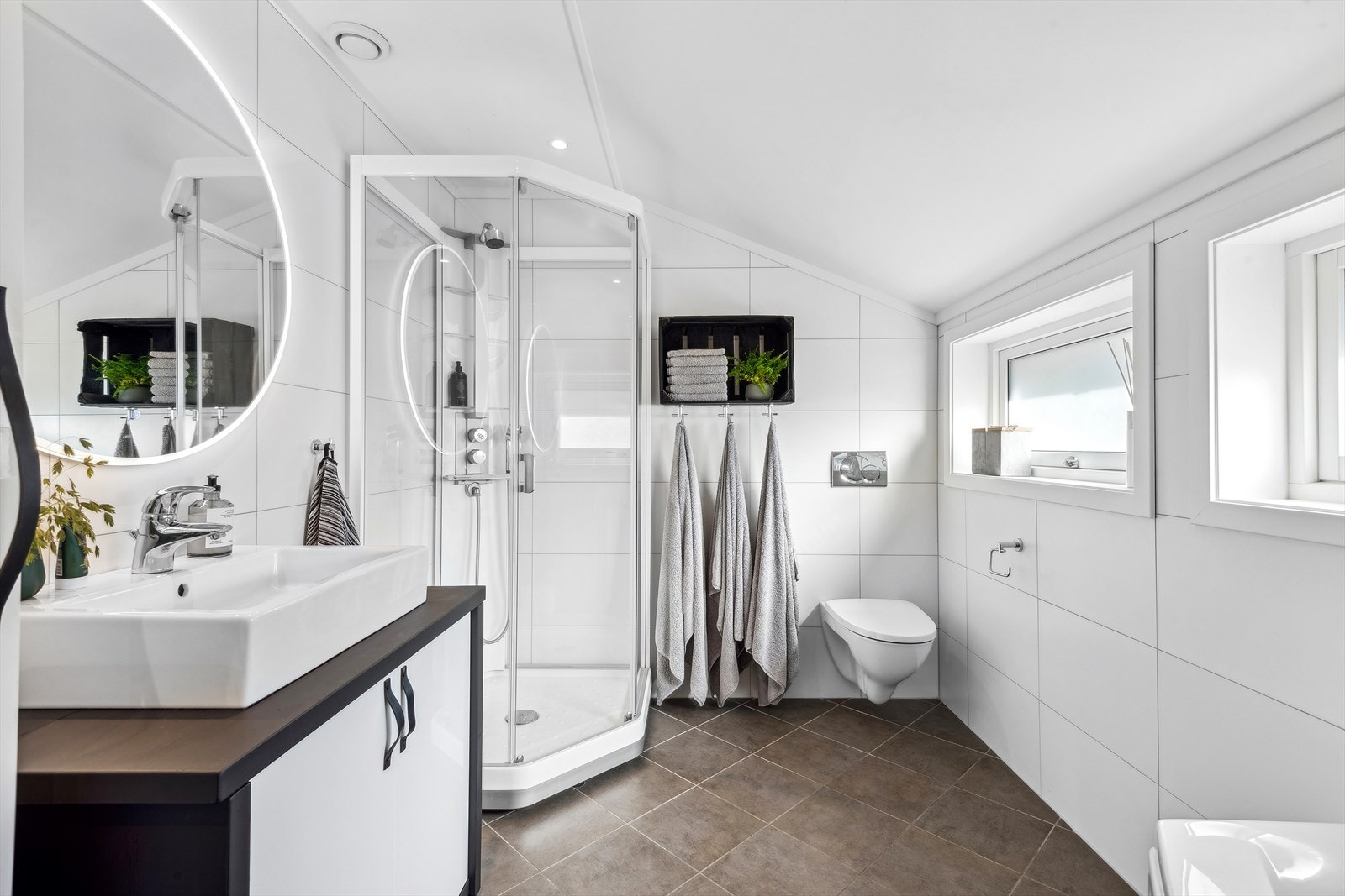 Baderommet er innredet med baderomsinnredning med toppmontert servant, underskap med dører, veggmontert toalett, badekar og dusjkabinett. Ventilasjon er via balansert ventilasjon. Galleribilde