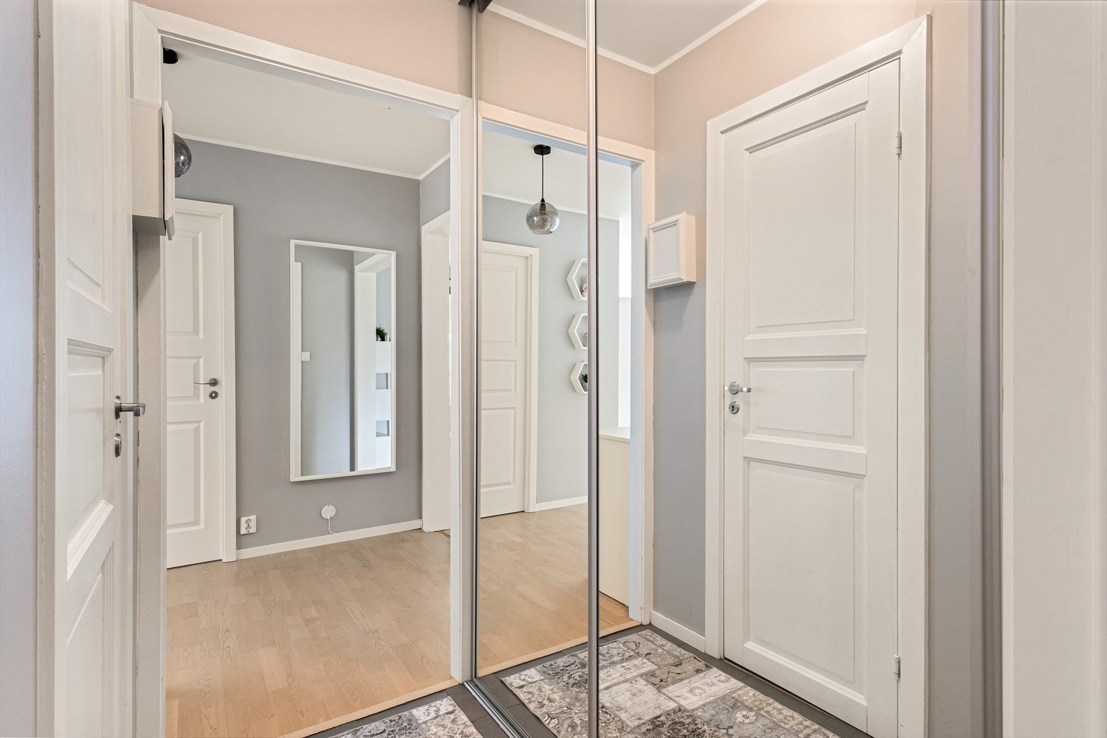 Entreen har skyvedørsgarderobe med speil langs hele veggen, perfekt for oppbevaring av klær og sko. Galleribilde