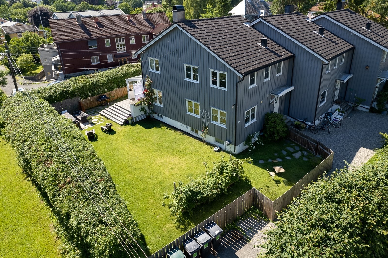 Tomten er pent opparbeidet med stor plen, hekk og prydbusker Galleribilde