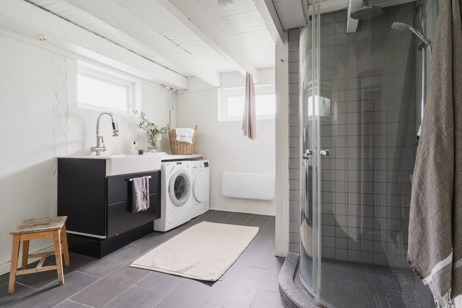 Bad utstyrt med dusjhjørne, stoppekran, opplegg for vaskemaskin, servantskap og servant Galleribilde