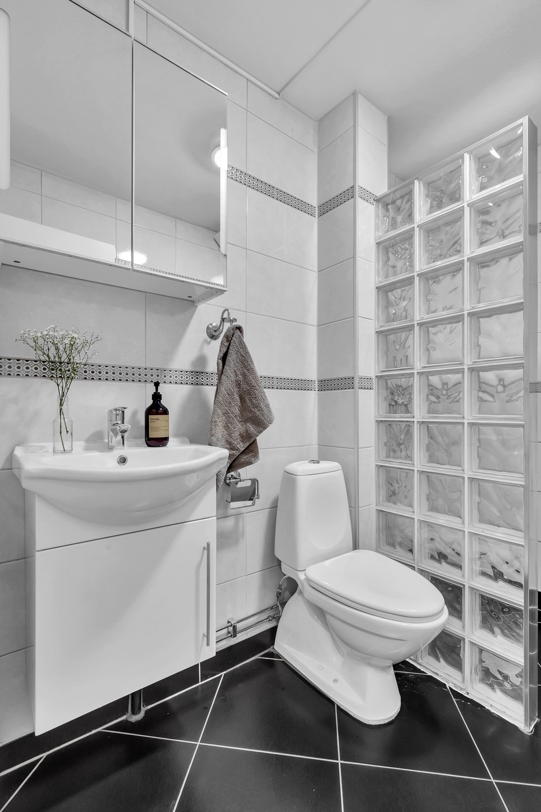 Innredet med klosett, servant med innredning, speilskap m/lys og dusjhjørne med glassvegg. Galleribilde