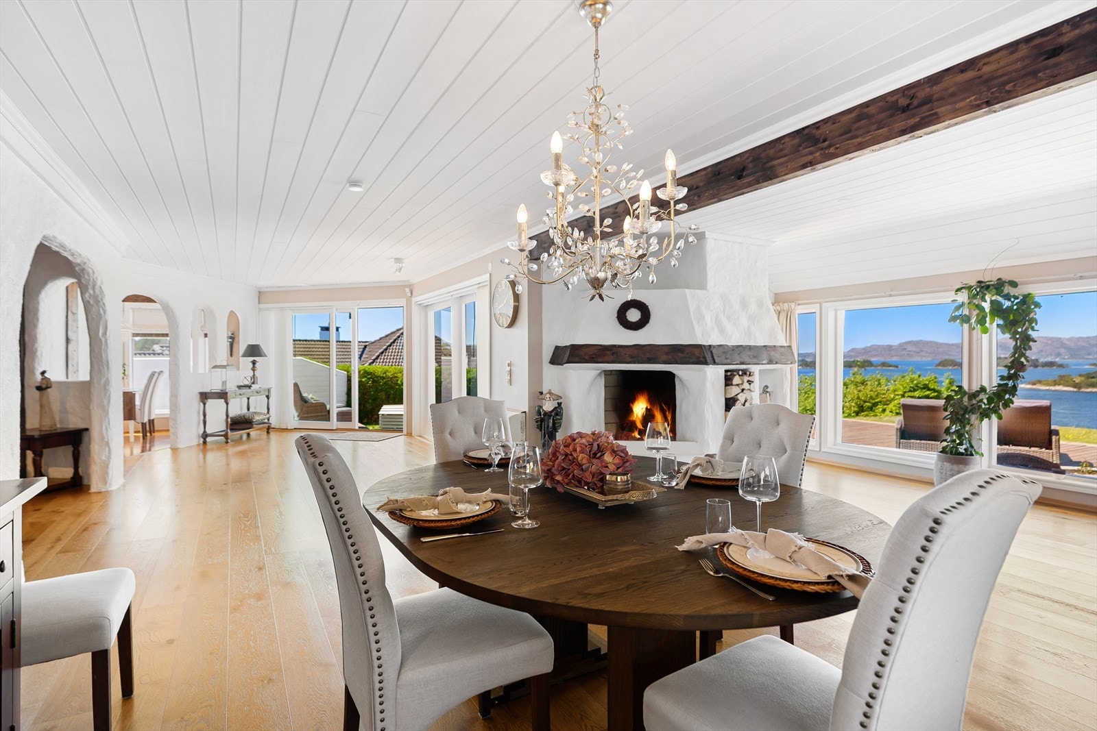 Meget stor stue med peis og store vinduer som dra lys og utsikt inn i boligen. Galleribilde