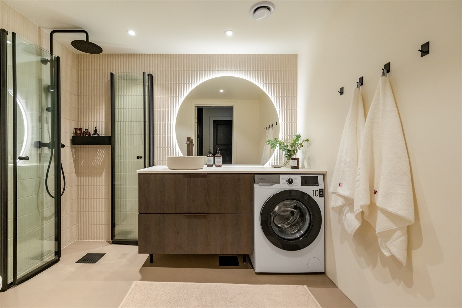 Stort, strøkent baderom som ble pusset opp i 2024. Badet har mikrosement og fliser i behagelige fargetoner på vegger og mikrosement med varmekabler i gulv. Malte plater med downlights i tak. Galleribilde