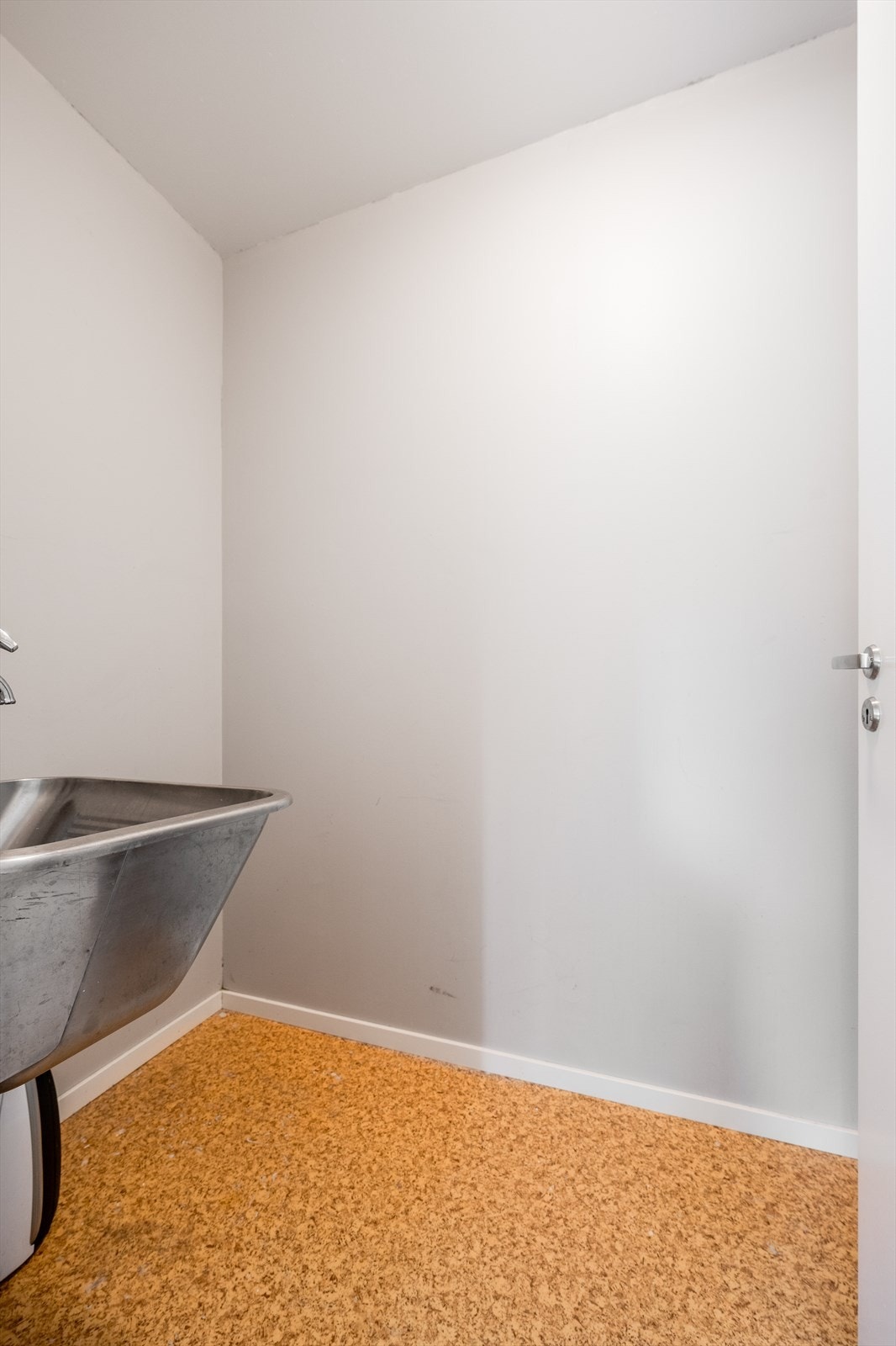 På innsiden av kjøkkenet er det en praktisk bod med belegg på gulv. Her er det opplegg til vaskemaskin og veggmontert utslagsvask. Galleribilde