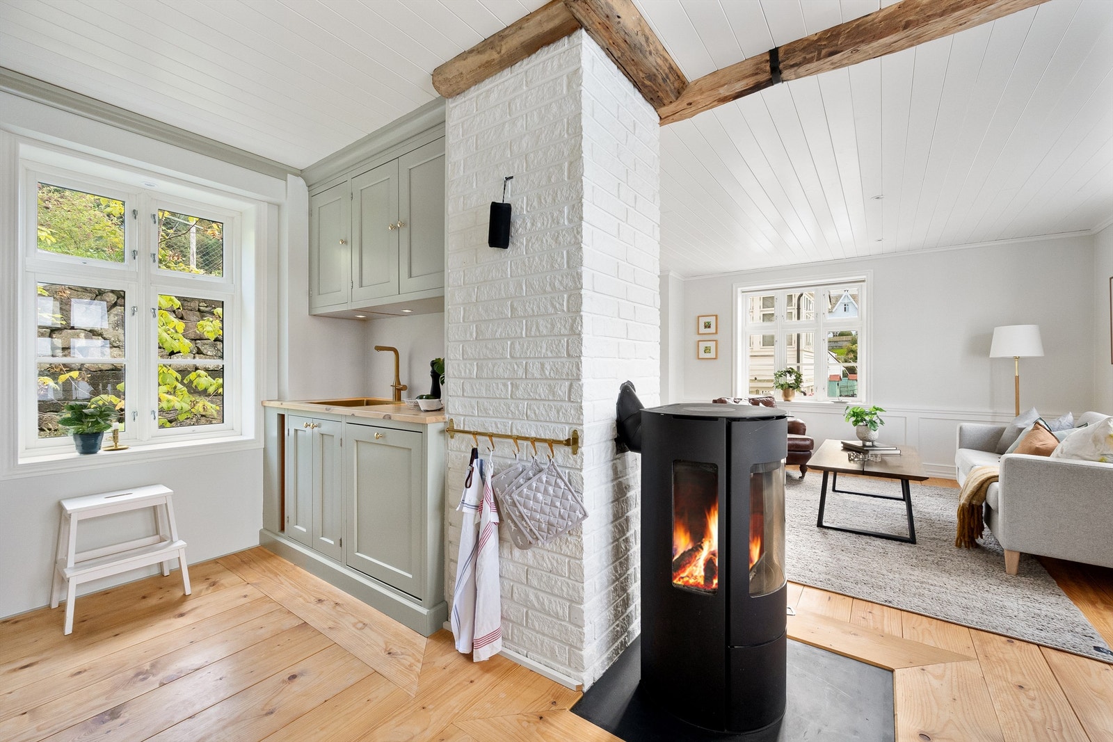 Moderne og effektiv peisovn i skille mellom kjøkken og stue. Galleribilde