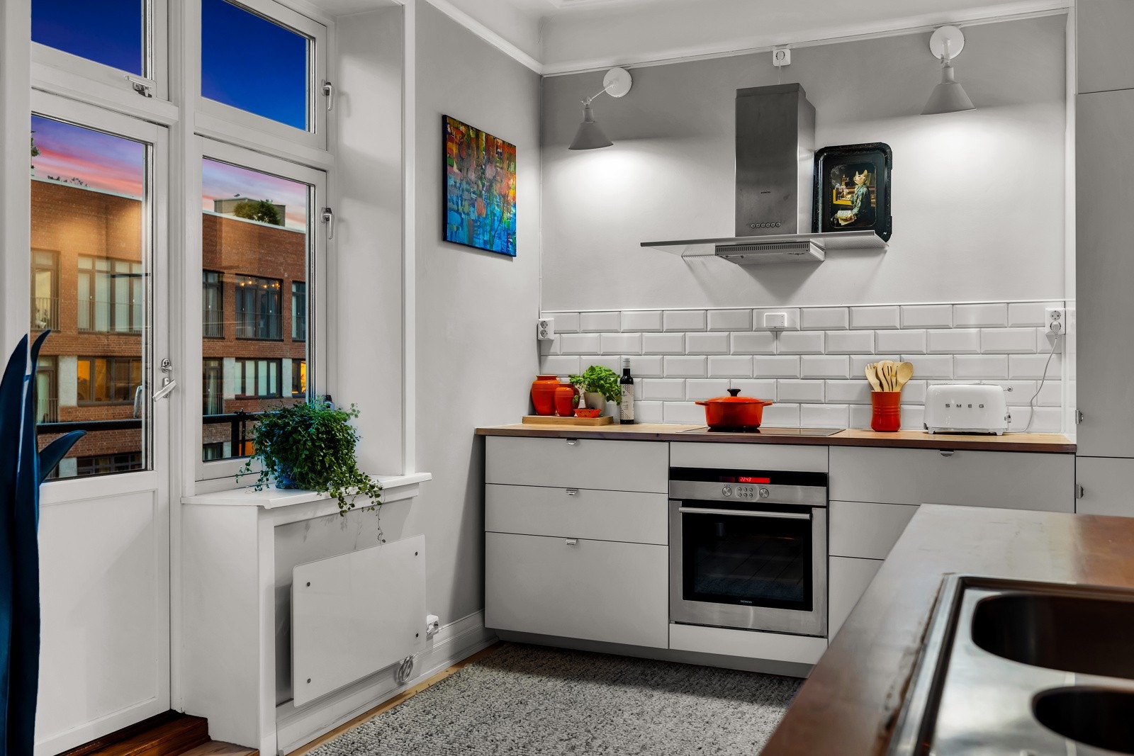 Romslig, stilrent kjøkken med hvit innredning og heltre benkeplate. Galleribilde