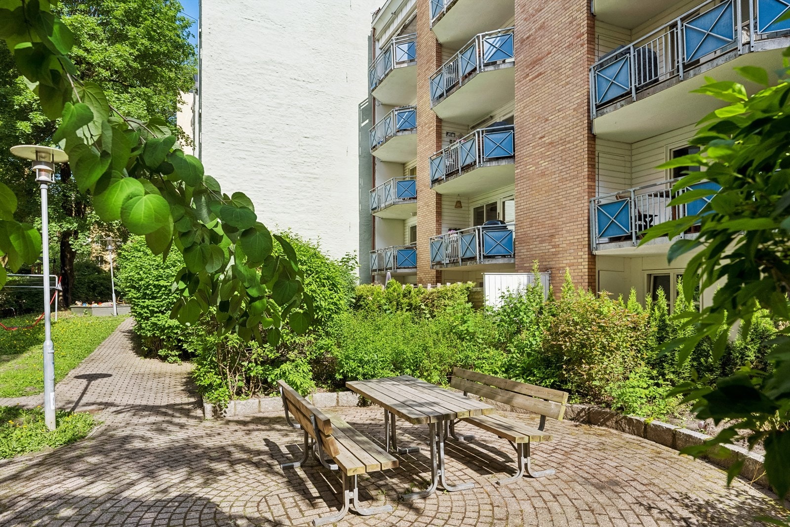 Borettslagets eiendom er pent opparbeidet med plenarealer, beplantninger, trær, felles lekeområde/lekeplass og sittebenker. Galleribilde