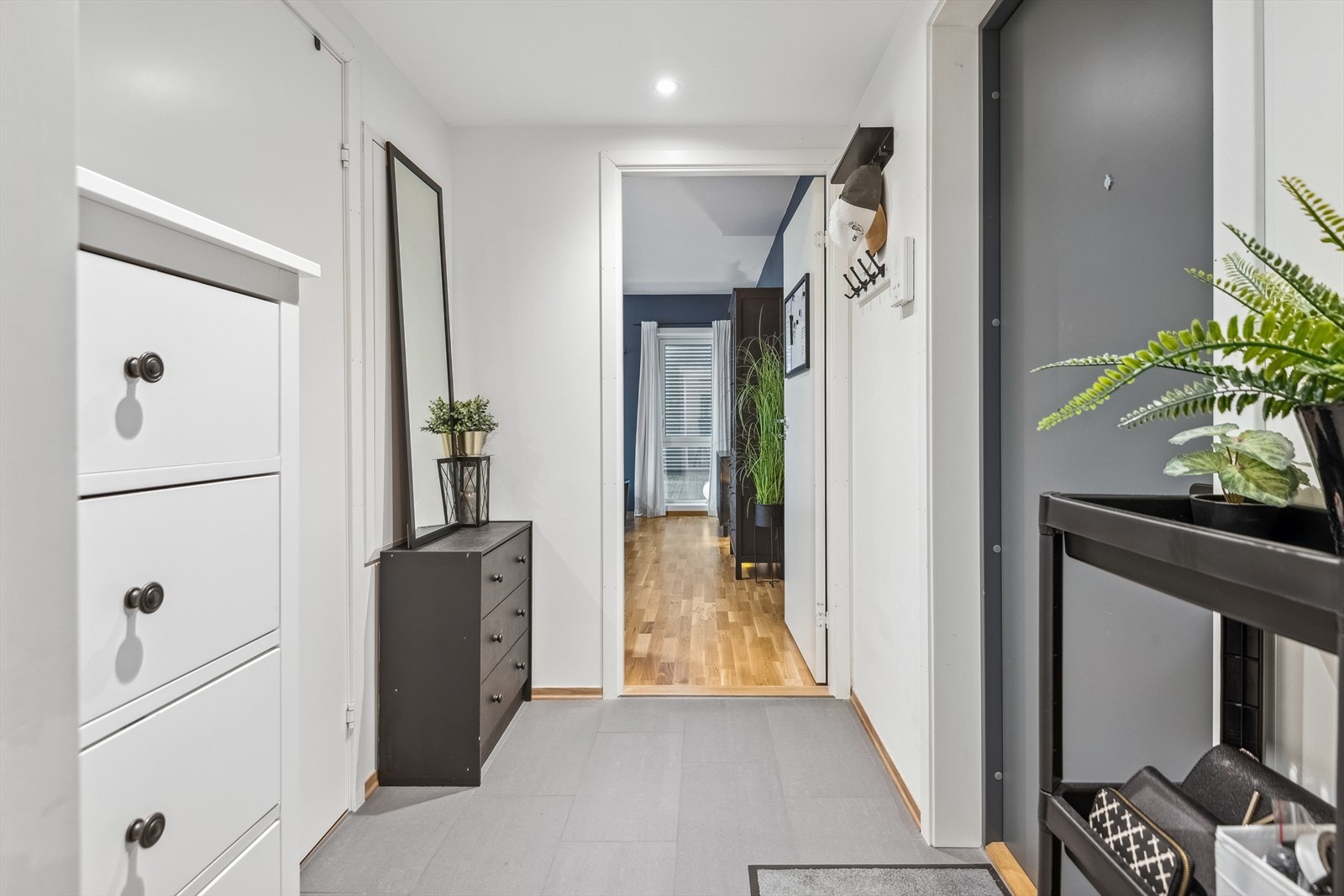 Videre fra stuen har man en flislagt gang med plass til oppbevaring. Badet ligger på venstre hånd. Galleribilde