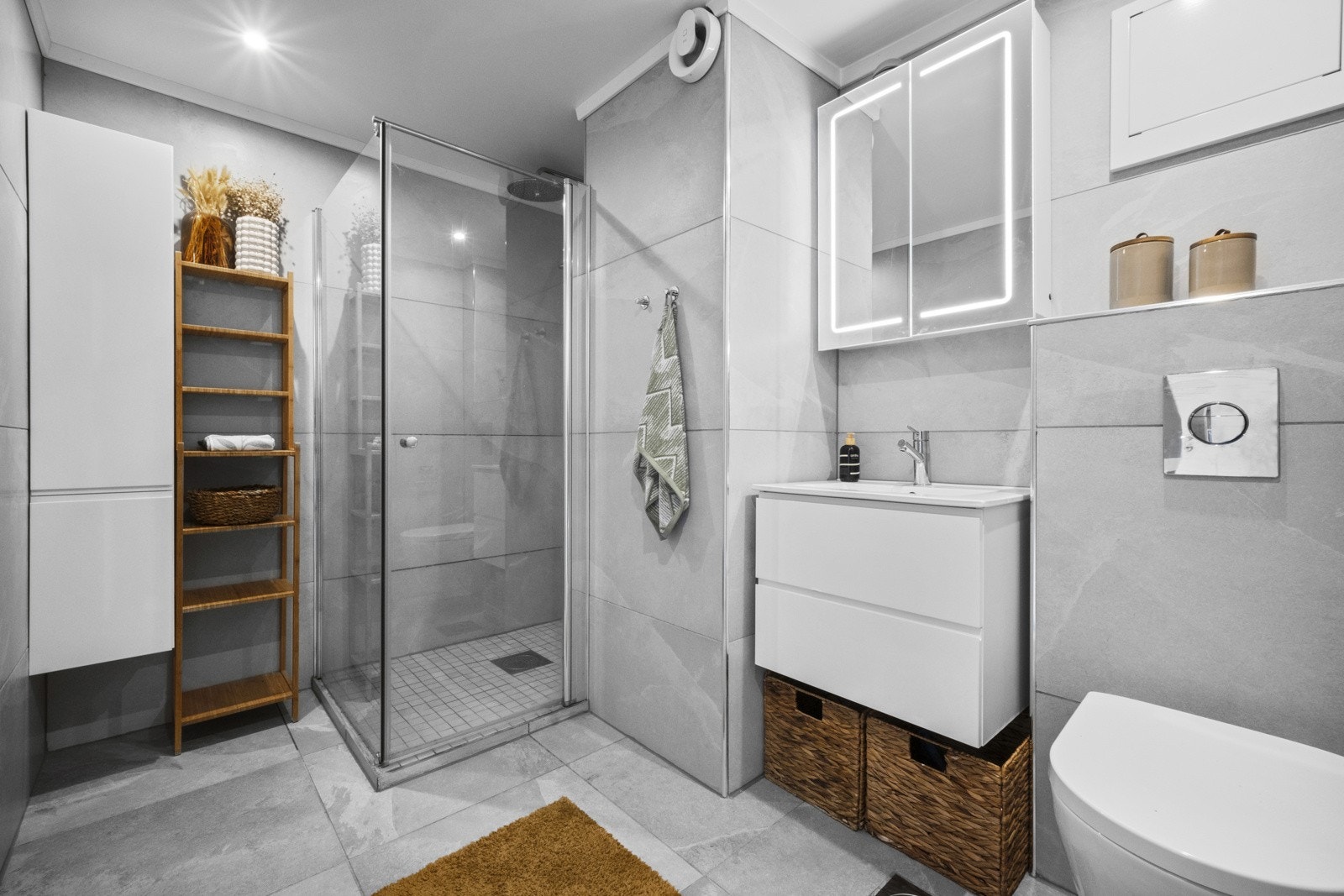 Lekkert helflislagt bad! Med et helflislagt bad og deilig gulvvarme skaper badet en behagelig atmosfære. Badet inneholder en et vegghengt toalett, hånvask med speil over og en forhøyet dusjnisje med glassdør/vegg. Galleribilde