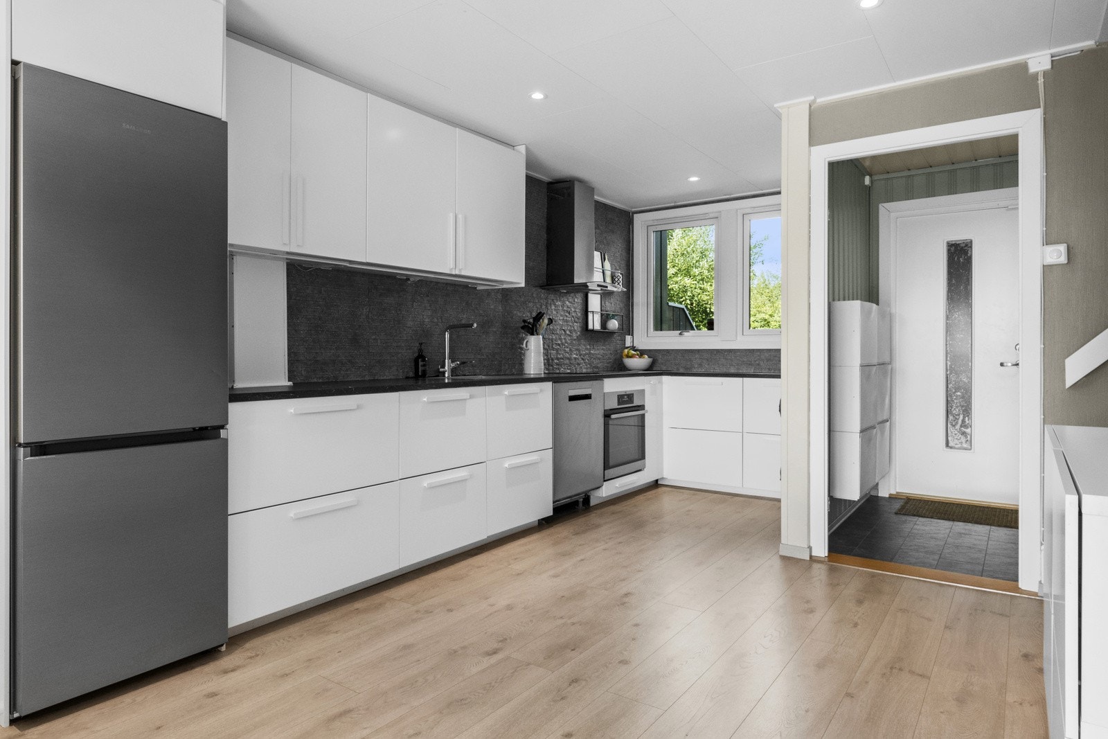 Lekkert kjøkken i tilknytning til stuen! Innredningen består av glatte fronter og laminert benkeplate. Kjøkkenet er utstyrt med integrerte hvitevarer, med nisjer for frys/kjøleskap og oppvaskmaskin. Galleribilde